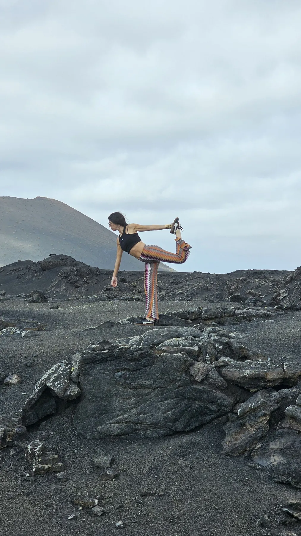 Laura en la postura del bailarín sobre un paisaje volcánico